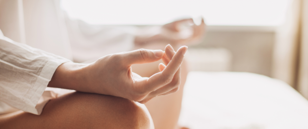 Hände, deren Daumen und Ringfinger sich berühren in der typischen Yogapose.