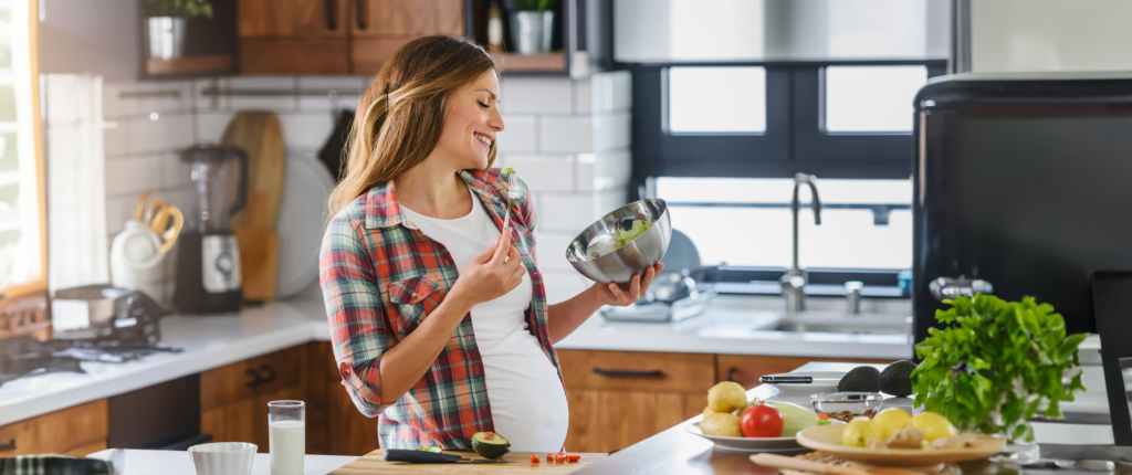 Schwangere Frau die Salat isst.